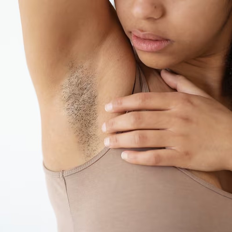 A woman checking regrowth in her underarm
