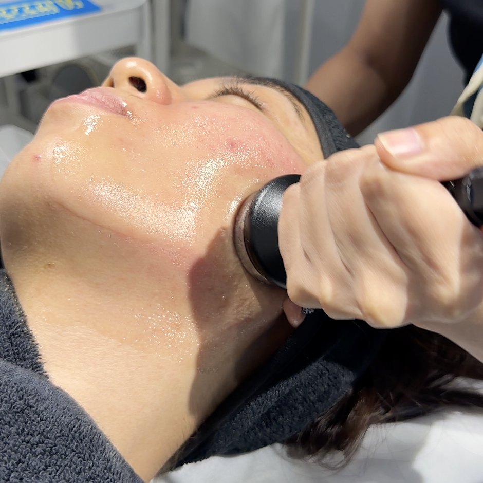 A therapist treating a client's jawline with a device